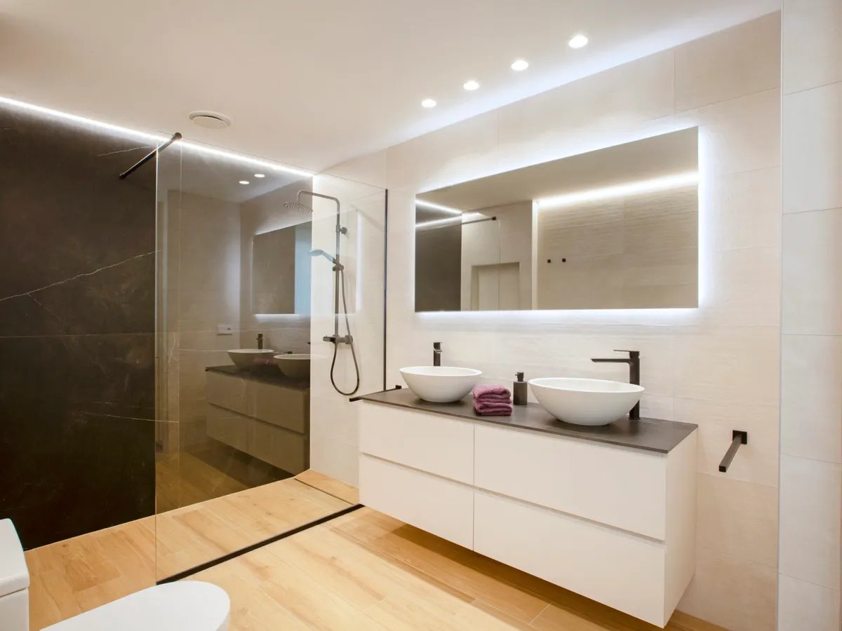 Reforma de bano en Valencia con ducha de obra, inodoro y mueble de lavabo suspendido en acabado madera